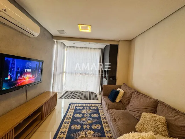 Sala de estar com sofá e televisão em um apartamento.