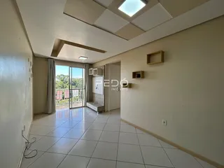Sala de estar com piso de cerâmica e teto inclinado em um imóvel no Brasil.