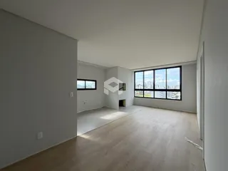 Interior de uma sala com piso de madeira e grande janela.