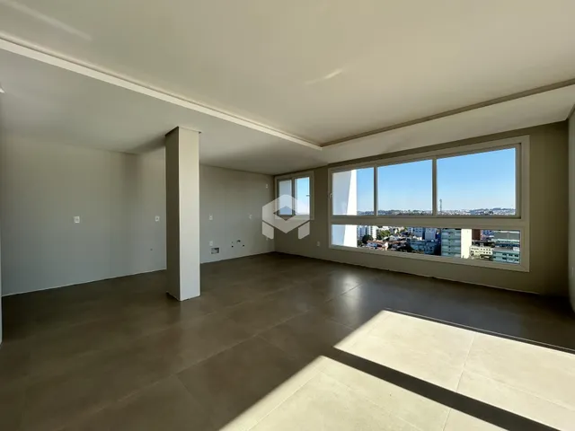 Sala de estar ampla com grandes janelas que oferecem vista para a paisagem urbana.