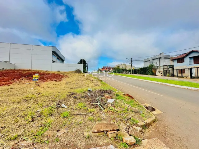 Vista externa de uma propriedade com terreno gramado e construções adjacentes.