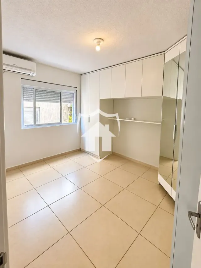 Foto de uma sala com piso de cerâmica e armários embutidos brancos.