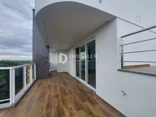 Balcão moderno com piso de madeira e vista da propriedade.