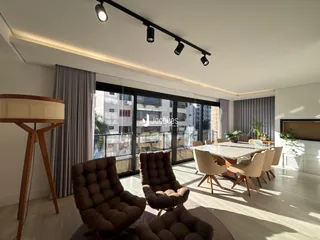 Sala de estar moderna com grandes portas de vidro e piso de madeira.