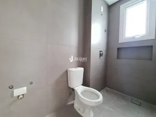 Foto de um banheiro interno com azulejos cinzas e um vaso sanitário branco.