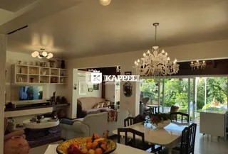 Sala de estar com sofá e vista para o jardim externo.