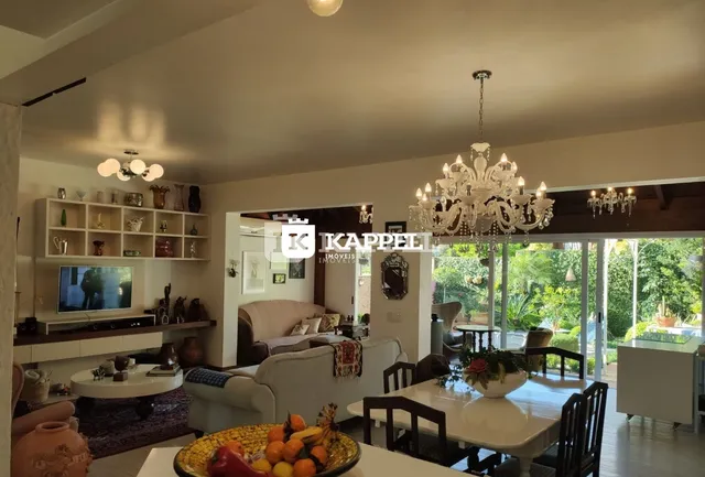 Sala de estar com sofá e vista para o jardim externo.