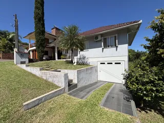 Vista externa de uma casa com jardim e garagem em Lajeado, Brasil.