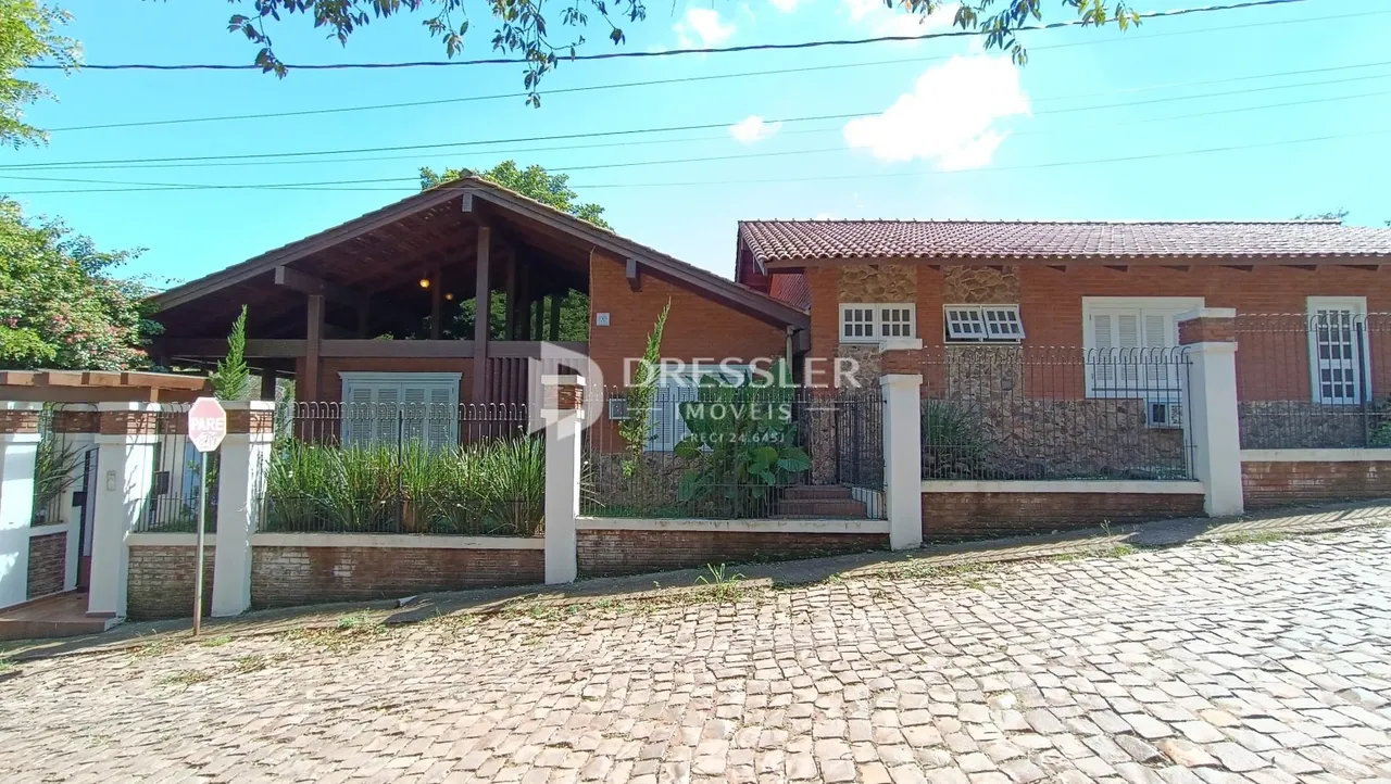 Fachada de uma residência em Lajeado, Brasil, com muro e paisagismo.