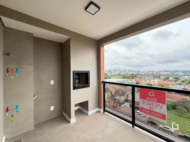 Interior de uma sala com vista para a paisagem urbana.