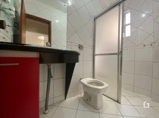 Banheiro com revestimento de azulejos brancos.