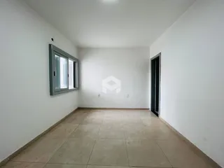 Vista interna de uma sala com piso de cerâmica e paredes brancas.