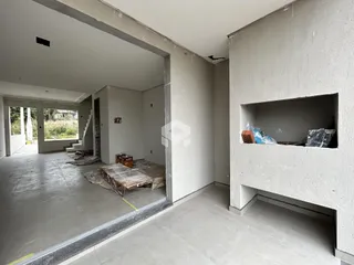 Interior de uma área em construção com paredes de concreto exposto.