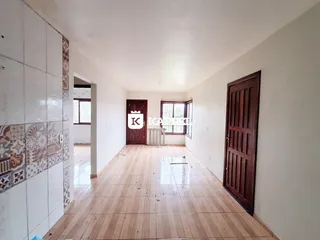 Foto de um ambiente interno com piso de madeira clara e paredes brancas.