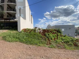 Fachada de um prédio residencial com vegetação no primeiro plano.