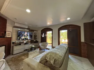 Sala de estar com sofá e televisão em um imóvel no Brasil.