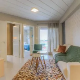Sala de estar com sofá e cortinas claras.