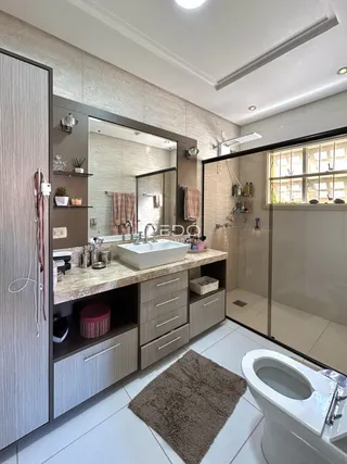 Banheiro moderno com bancada e box de vidro.