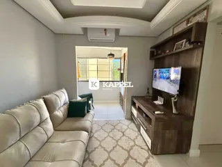 Sala de estar com sofá e rack de TV em ambiente claro.