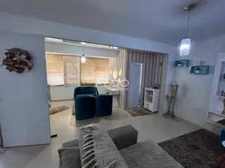Sala de estar com sofá e poltronas em um imóvel no Brasil.