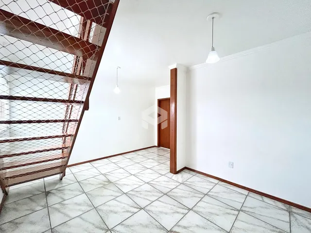 Interior de uma sala de estar com piso de cerâmica e paredes brancas.
