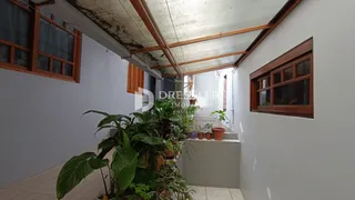 Foto de um ambiente interno com vigas de madeira expostas e plantas grandes.