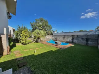 Foto da área externa com piscina e gramado de uma residência em Lajeado.