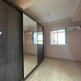 Hall de entrada com piso claro e espelho refletindo o ambiente.