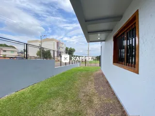 Vista externa da casa mostrando o muro e a área gramada.