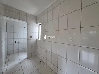 Corredor interno com paredes brancas e piso de cerâmica.