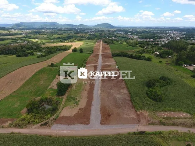 Vista aérea de uma área rural com campos abertos e estradas de terra.