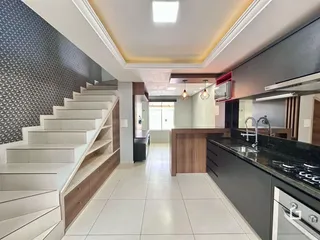 Hall de entrada com escadaria e cozinha moderna em um imóvel no Brasil.