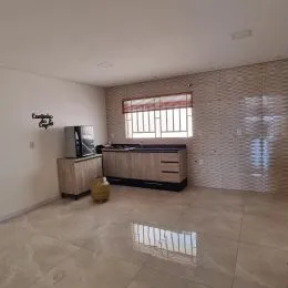 Uma sala de estar com piso de cerâmica e um móvel de madeira.
