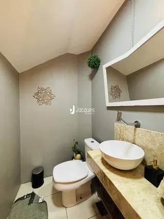 Foto de um banheiro com bancada e vasos sanitários.