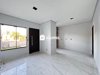 Sala ampla com piso de mármore claro e grande janela.