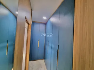 Vista interna de um corredor com paredes azuis e detalhes em madeira clara.