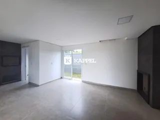 Sala ampla com piso de porcelanato e porta de vidro que dá acesso ao exterior.