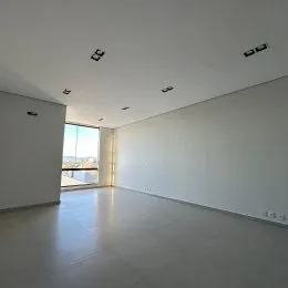 Hall de corredor com paredes brancas e abertura para a vista externa.