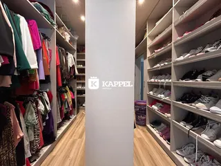 Hall de entrada com estantes de roupas e sapatos em um ambiente interno.