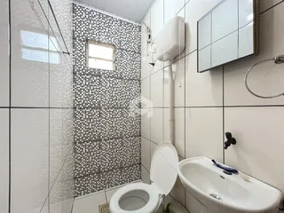 Banheiro com revestimento de azulejos brancos e pretos.