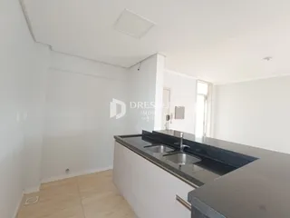 Vista interna de uma cozinha moderna com bancada escura.