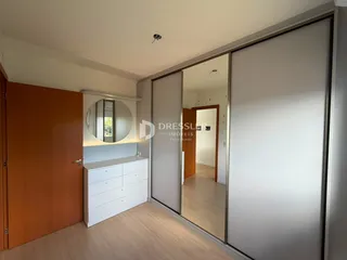 Quarto com porta de madeira e armário branco.