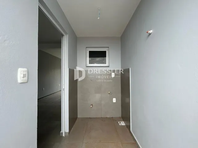 Hall de entrada com piso de cerâmica e parede clara.