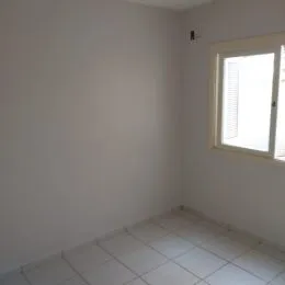 Parede branca e piso de cerâmica em um ambiente interno.