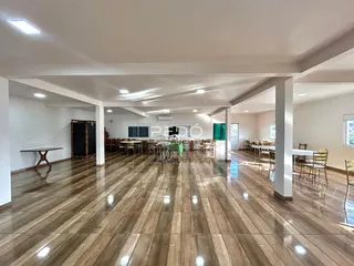 Interior de um ambiente amplo com piso de madeira polida.
