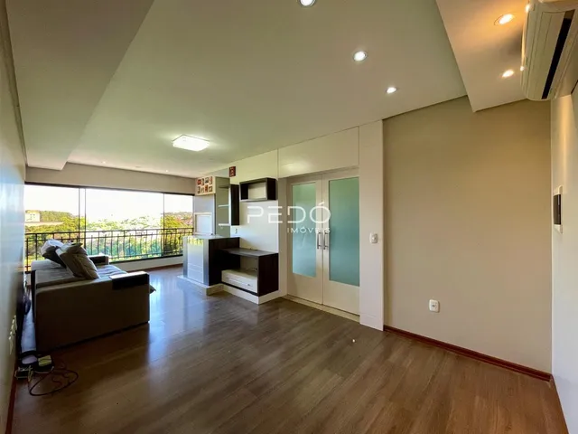 Sala de estar com piso de madeira e vista para o exterior.