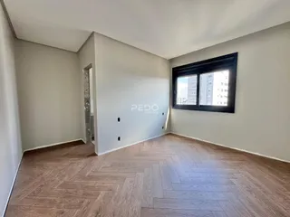 Ambiente interno com piso de madeira e parede clara.