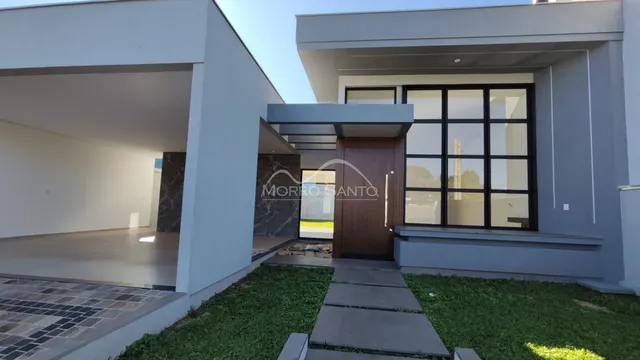 Fachada moderna de uma residência em Lajeado, Brasil, com grandes janelas de vidro.