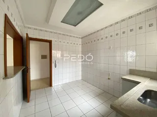 Interior de um ambiente com piso e paredes revestidos de cerâmica branca.