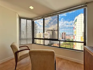 Sala de estar com vista para a cidade através de uma grande janela.
